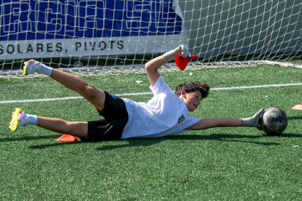 Porter en posició de bloqueig durant entrenament individual a camp de futbol